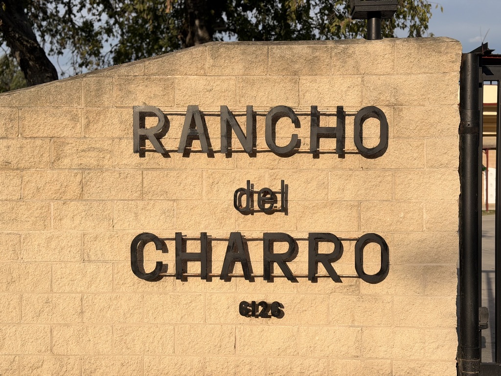 Rancho del Charro lettering on the stone entrance wall at the San Antonio lienzo